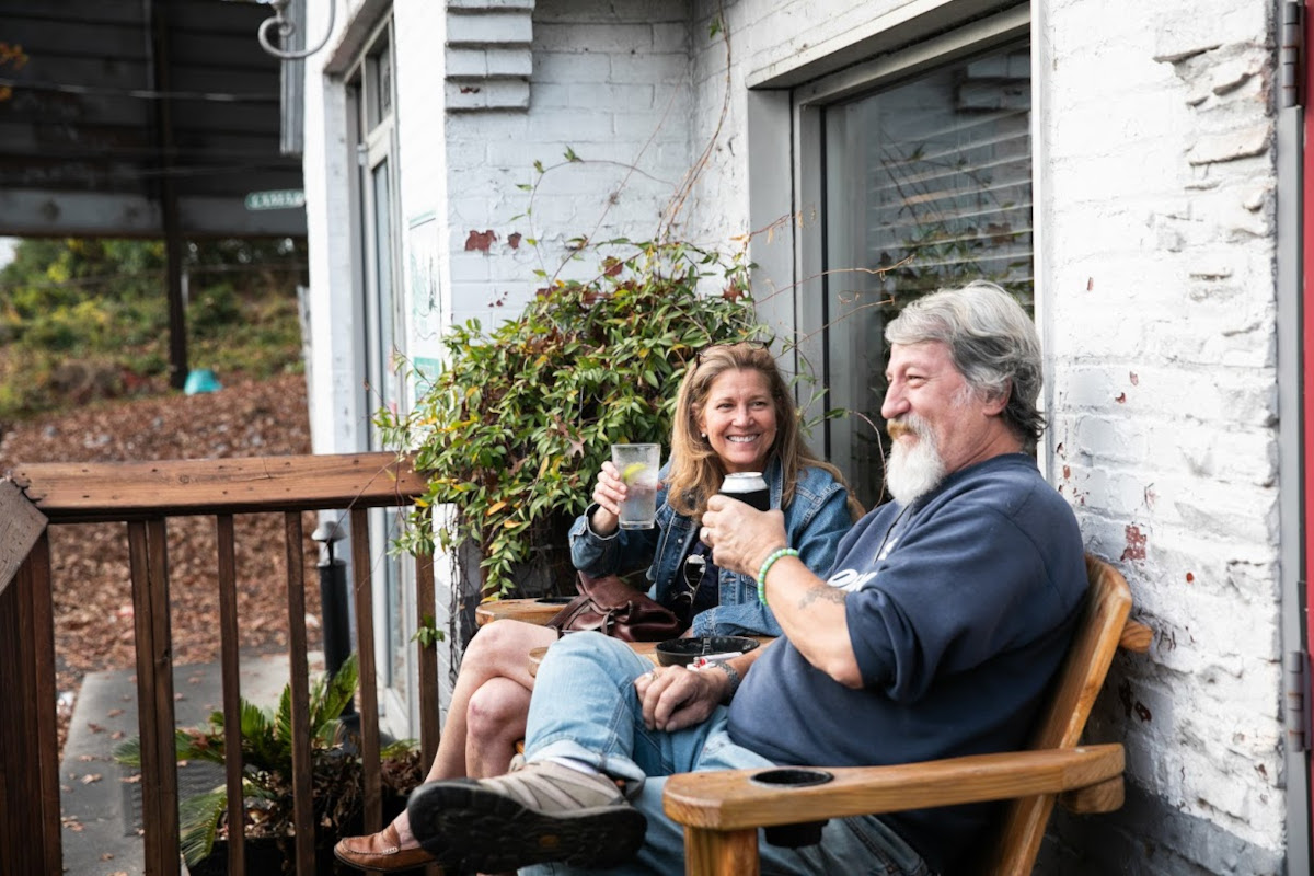 Two smiling people sitting on the terrace